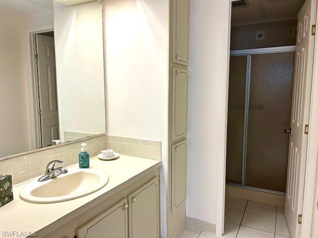 Image 4: Full bath featuring a shower stall, vanity, and light tile patterned floors