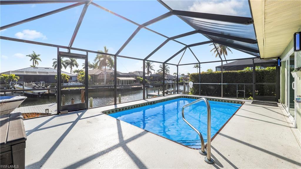 Image 2: Swimming pool with a lanai, a sunroom, a water view, a patio area, and a residential view
