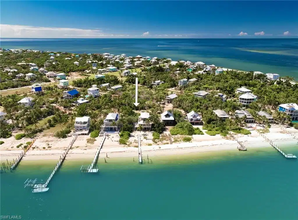 Image 1: Birds eye view of property with a water view and a view of the beach