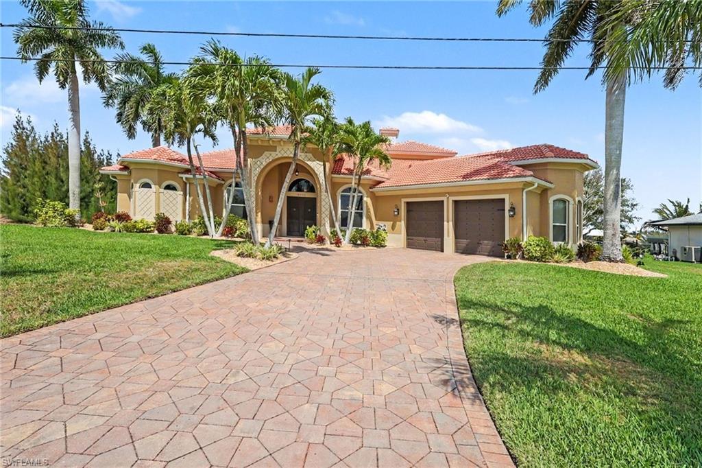 Image 1: Mediterranean / spanish-style house with a front lawn, stucco siding, a tile roof, decorative driveway, and a garage
