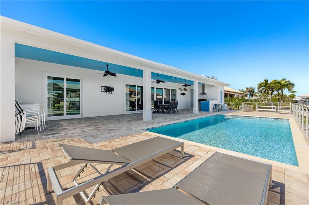 Image 2: View of swimming pool with outdoor dining space, a ceiling fan, fence, a fenced in pool, and a patio area