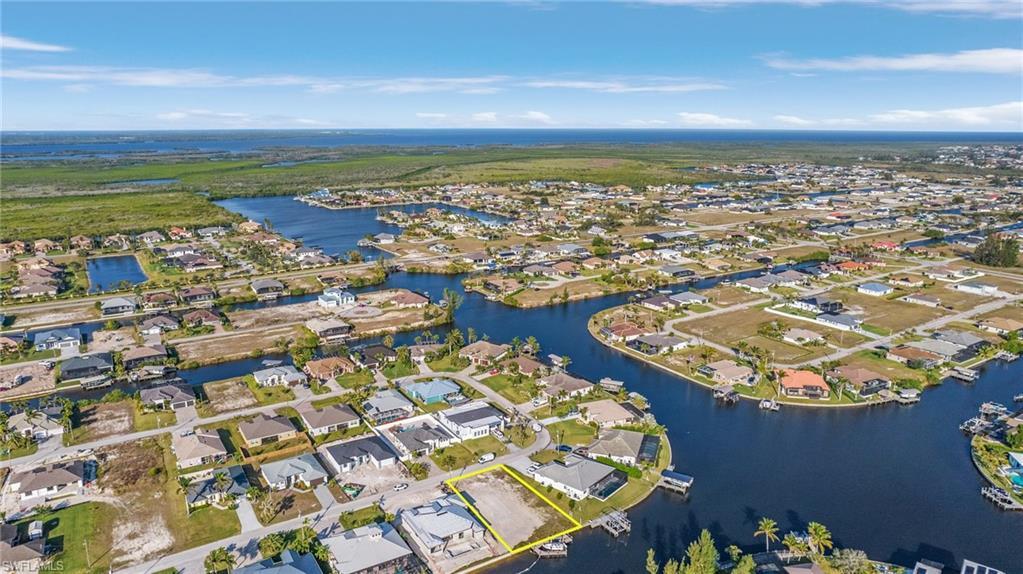 Image 2: Gulf Access lot with seawall, boat dock and lift northeastern rear exposure, about 20 min by boat to open water. 907 NW 38th Ave, Cape Coral FL 33993