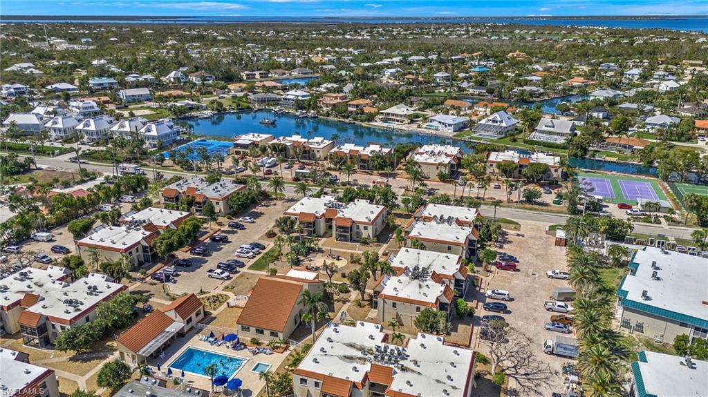 Image 3: Aerial view of residential area featuring a nearby body of water