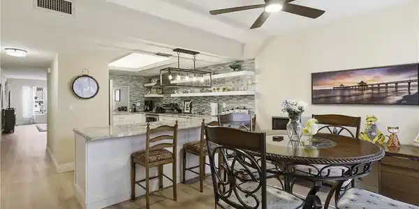 Image 3: Open-concept living space featuring wood-finish flooring and a contemporary ceiling fan