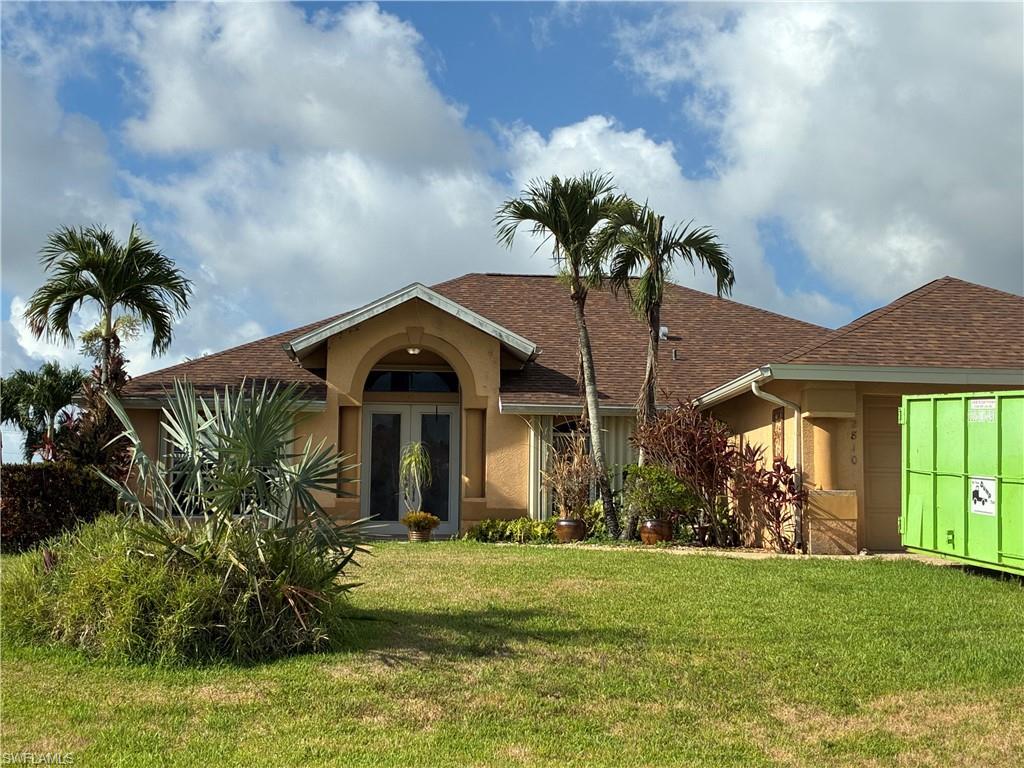 Image 2: Single-story residence featuring a classic arched entryway with double glass doors