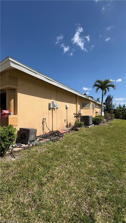 Image 4: Stucco exterior with multiple HVAC units and a manicured lawn