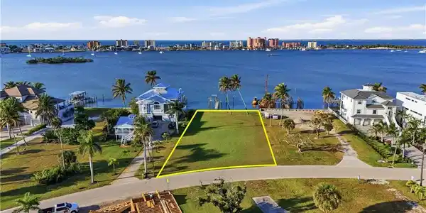 Image 3: View of urban area with a nearby body of water and property boundaries highlightedchange color of water into natural dark blue canal water