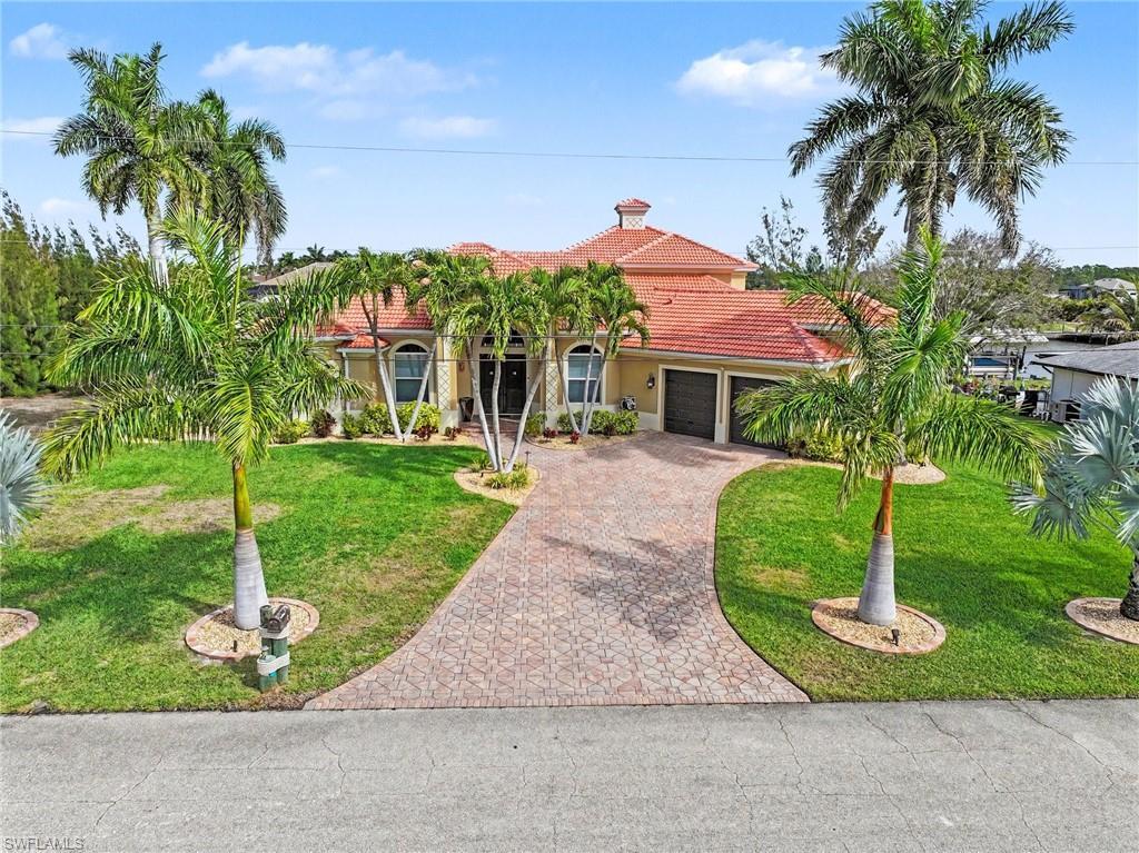 Image 4: Mediterranean / spanish home featuring a tile roof, decorative driveway, an attached garage, stucco siding, and a front yard