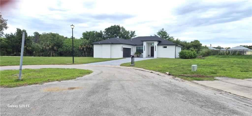 Image 4: Contemporary single-story residence featuring a white stucco exterior and dark shingle roof