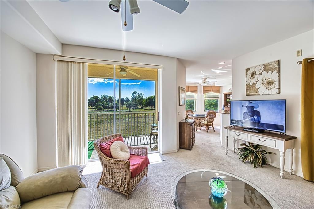 Image 4: Living area with carpet and a sunroom