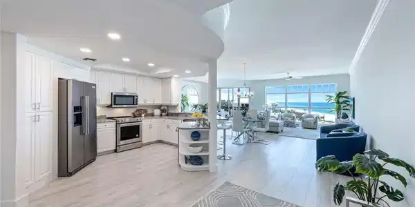 Image 4: Kitchen featuring stainless steel appliances, open floor plan, white cabinetry, light wood finished floors, and recessed lighting