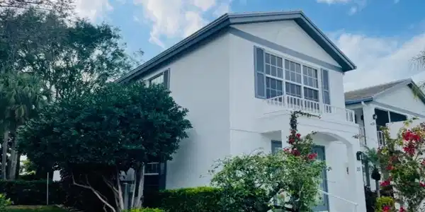 Image 3: View of front of home featuring a balcony and stucco siding