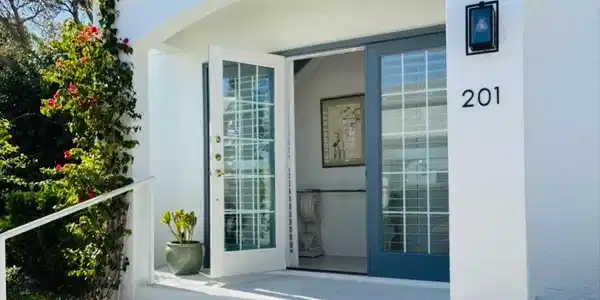 Image 4: View of exterior entry featuring stucco siding