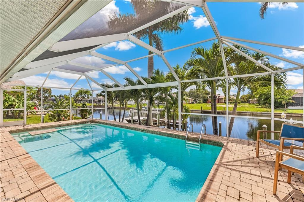 Image 2: Outdoor pool featuring a water view, a patio, and glass enclosure