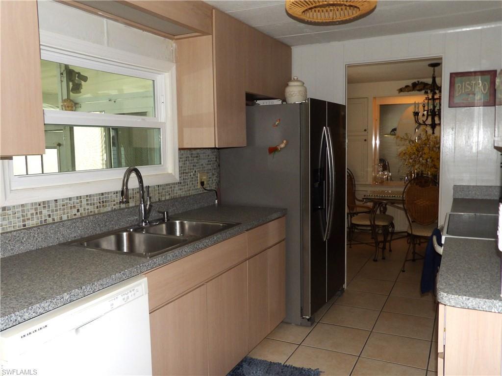 Image 4: Kitchen featuring light cabinets, dishwasher, stainless steel refrigerator with ice dispenser, range with electric stovetop, and light tile patterned floors