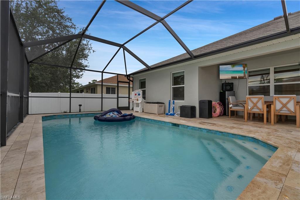 Image 2: View of pool featuring a sunroom, a patio area, and a lanai