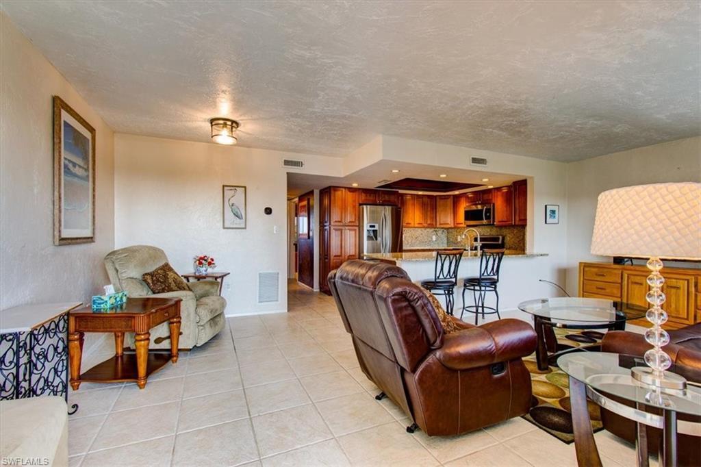 Image 2: Tiled living room with a textured ceiling and sink