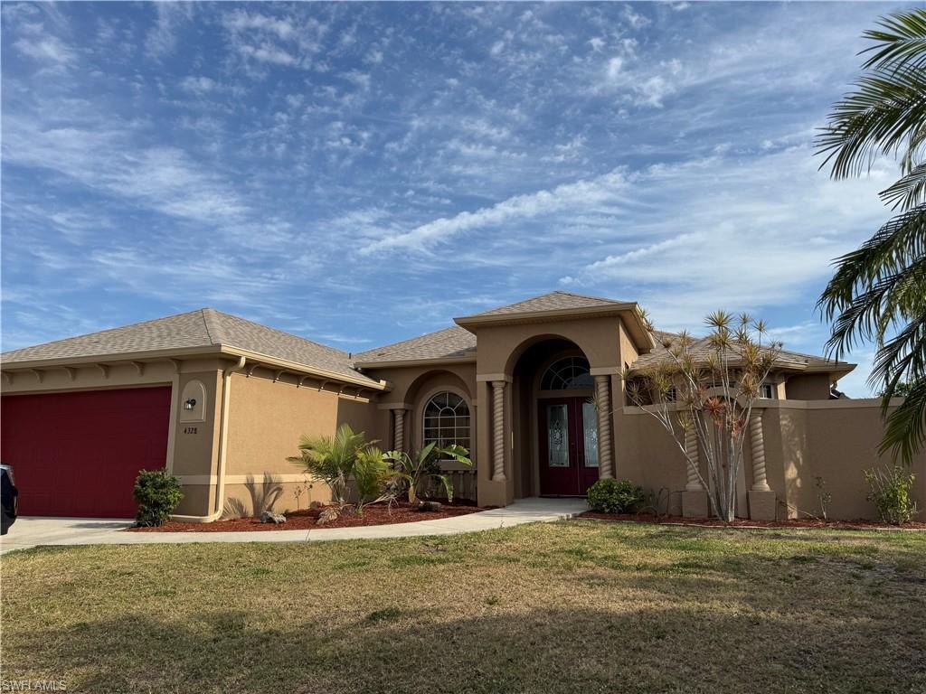 Image 1: Mediterranean / spanish home featuring driveway, a front yard, stucco siding, a garage, and french doors