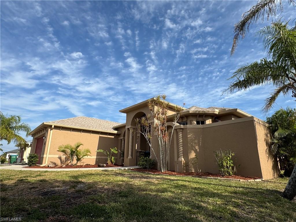 Image 2: Mediterranean / spanish home featuring a front lawn, driveway, stucco siding, an attached garage, and french doors
