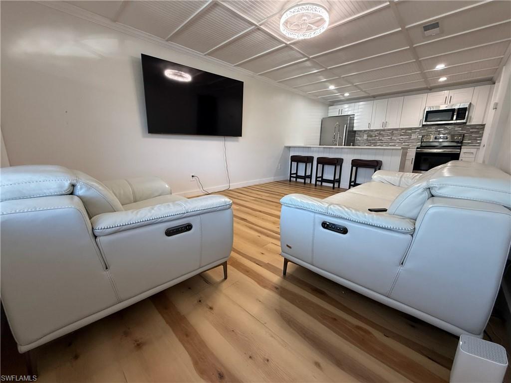 Image 3: Living room with light wood-style flooring and recessed lighting