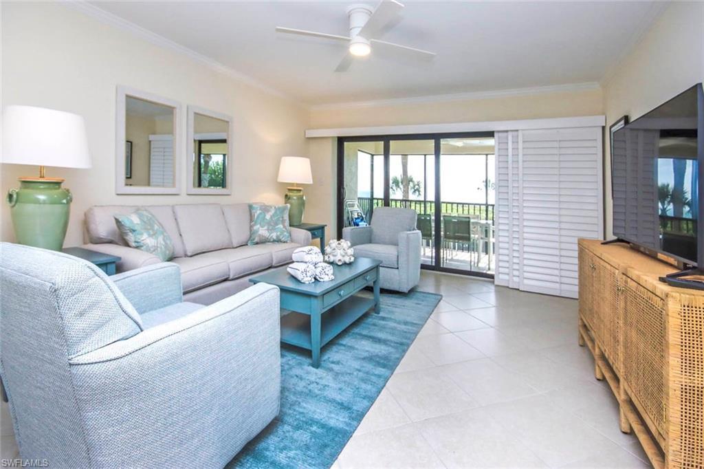 Image 2: Living area with crown molding, light tile patterned floors, and ceiling fan