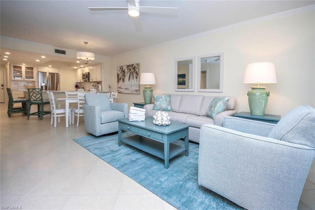 Image 3: Living area featuring crown molding, light tile patterned flooring, and a ceiling fan