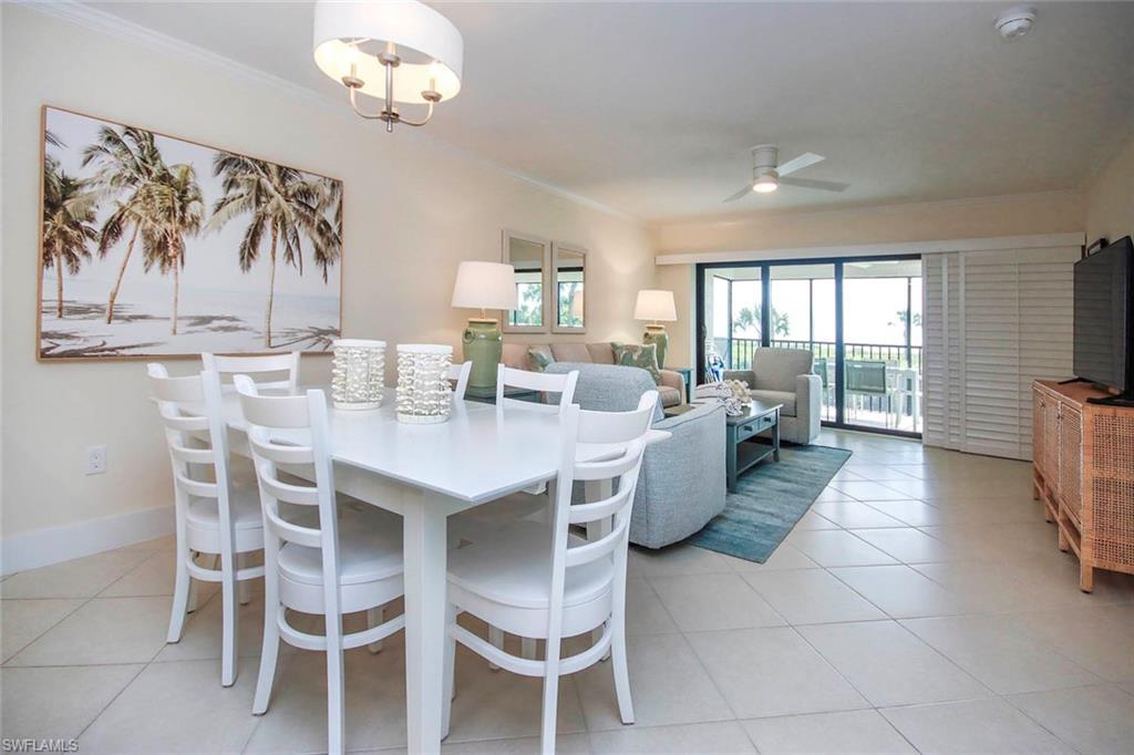 Image 4: Dining area featuring ornamental molding, light tile patterned floors, a ceiling fan, and a chandelier