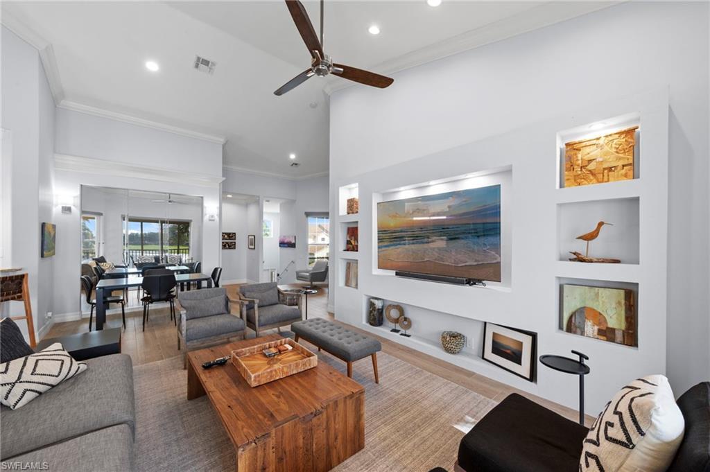 Image 4: Open-concept living area featuring soaring ceilings with ceiling fan, recessed lighting, and abundant natural light from multiple windows