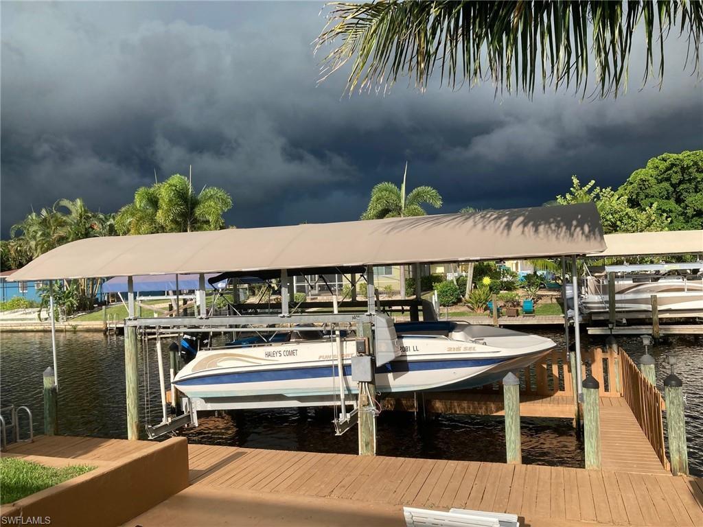Image 2: Dock area featuring boat lift and a water view