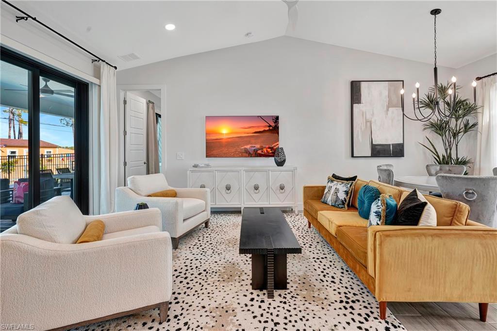 Image 1: Living room featuring vaulted ceiling, a chandelier, and recessed lighting