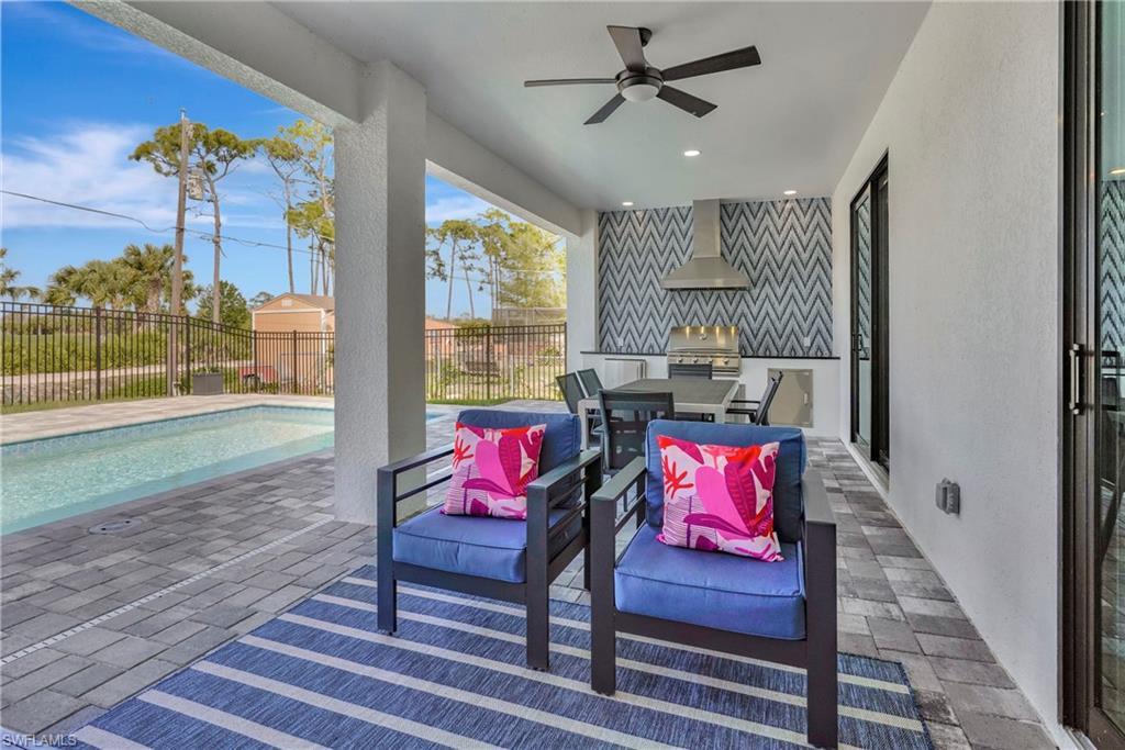 Image 4: Fenced backyard featuring an outdoor kitchen, a patio area, and a ceiling fan