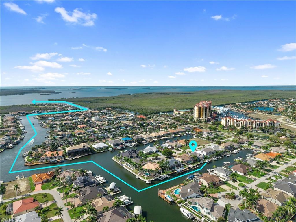 Image 1: Aerial perspective of suburban area featuring a nearby body of water