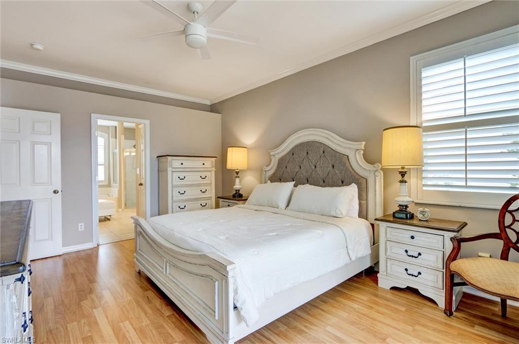 Image 2: Spacious room featuring wood-finish flooring, a ceiling fan, crown molding, and a window with plantation shutters