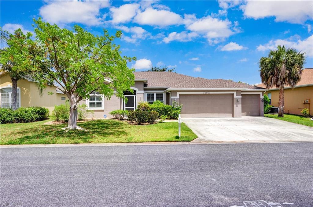 Image 3: Single-story residence featuring a two-car garage, concrete driveway, and a screened front entry