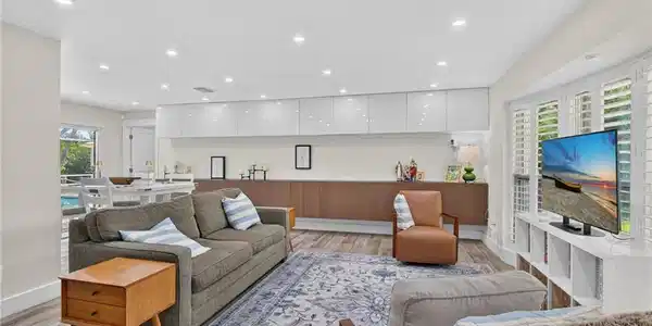 Image 3: The living room features custom cabinetry up and down for massive storage.