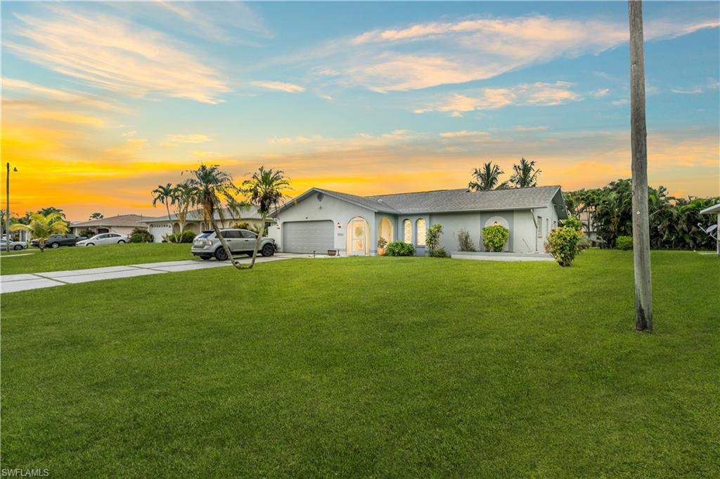 Image 2: Ranch-style home with concrete driveway, a front yard, an attached garage, and stucco siding