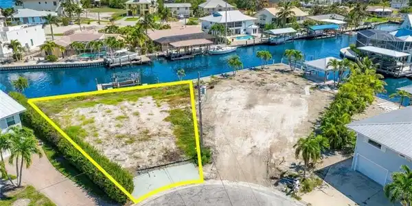 Image 2: Waterfront lot with direct canal access, featuring a seawall and cul-de-sac frontage - Virtually Edited Image
