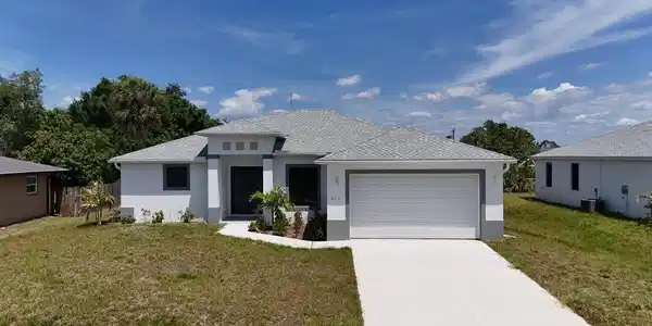 Image 2: Contemporary single-story residence featuring a two-car garage, concrete driveway, and a light gray shingle roof
