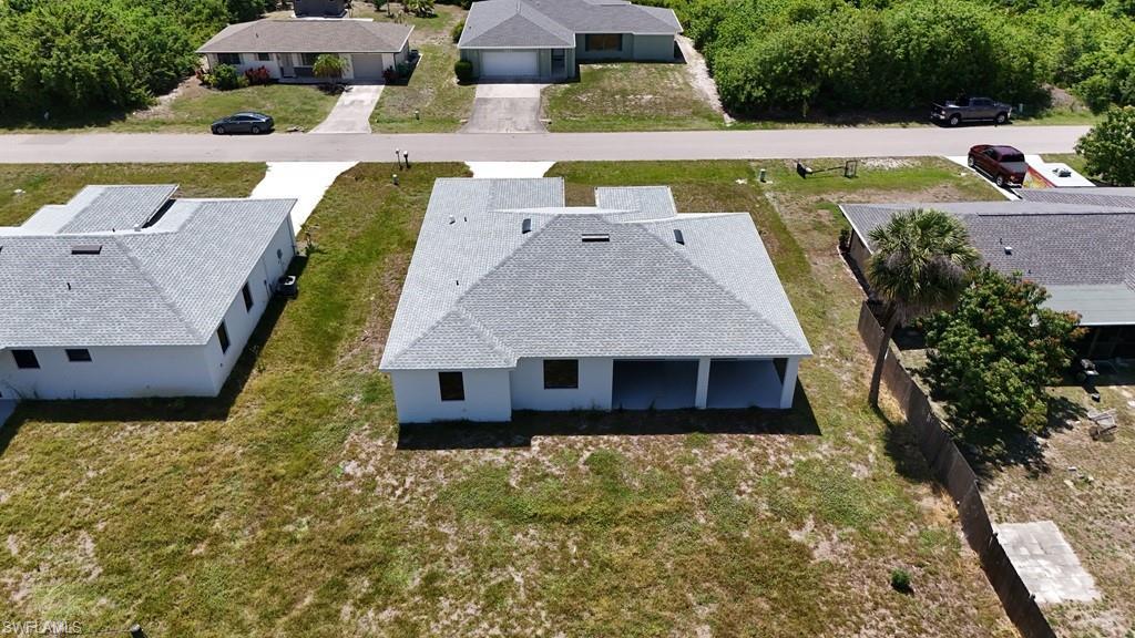 Image 3: New construction residence featuring a light gray shingle roof, white exterior walls, and a covered patio