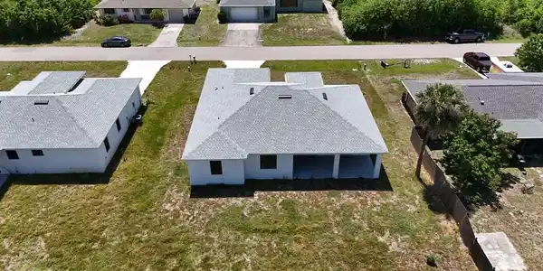 Image 3: New construction residence featuring a light gray shingle roof, white exterior walls, and a covered patio