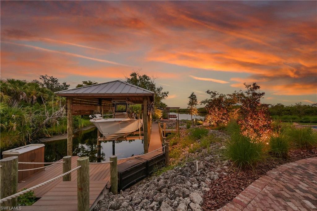 Image 4: Private composite dock featuring a covered boat lift with room for 28 ft boat, fish cleaning station, and direct access to Deep Creek- perfect for boating and waterfront living