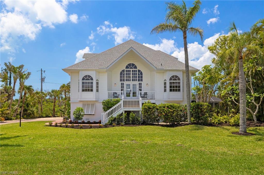 Image 3: Front view of house featuring a lawn, roof with shingles, stairway, and a balcony