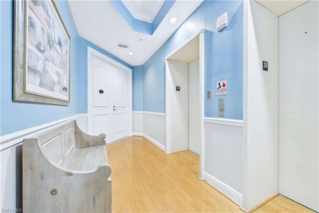 Image 3: Hallway with elevator, light wood finished floors, crown molding, and recessed lighting