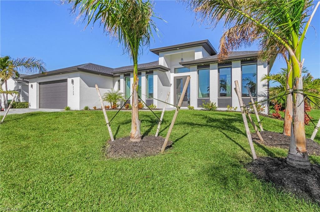 Image 2: View of front of property with a front lawn and a garage