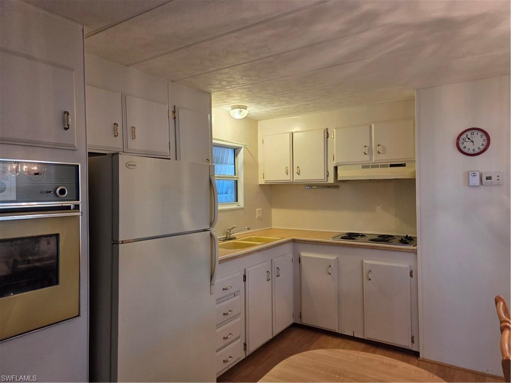 Image 4: Bright, cheery kitchen with laminate flooring.
