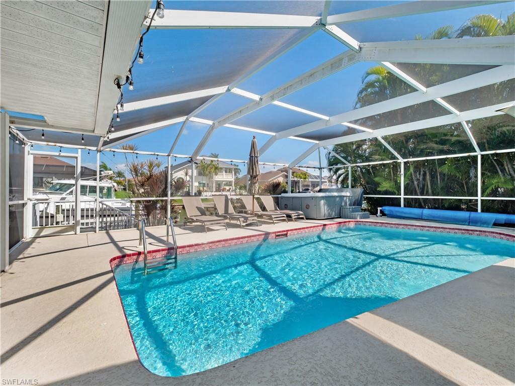 Image 3: Outdoor pool with a sunroom, a patio, a hot tub, and a lanai