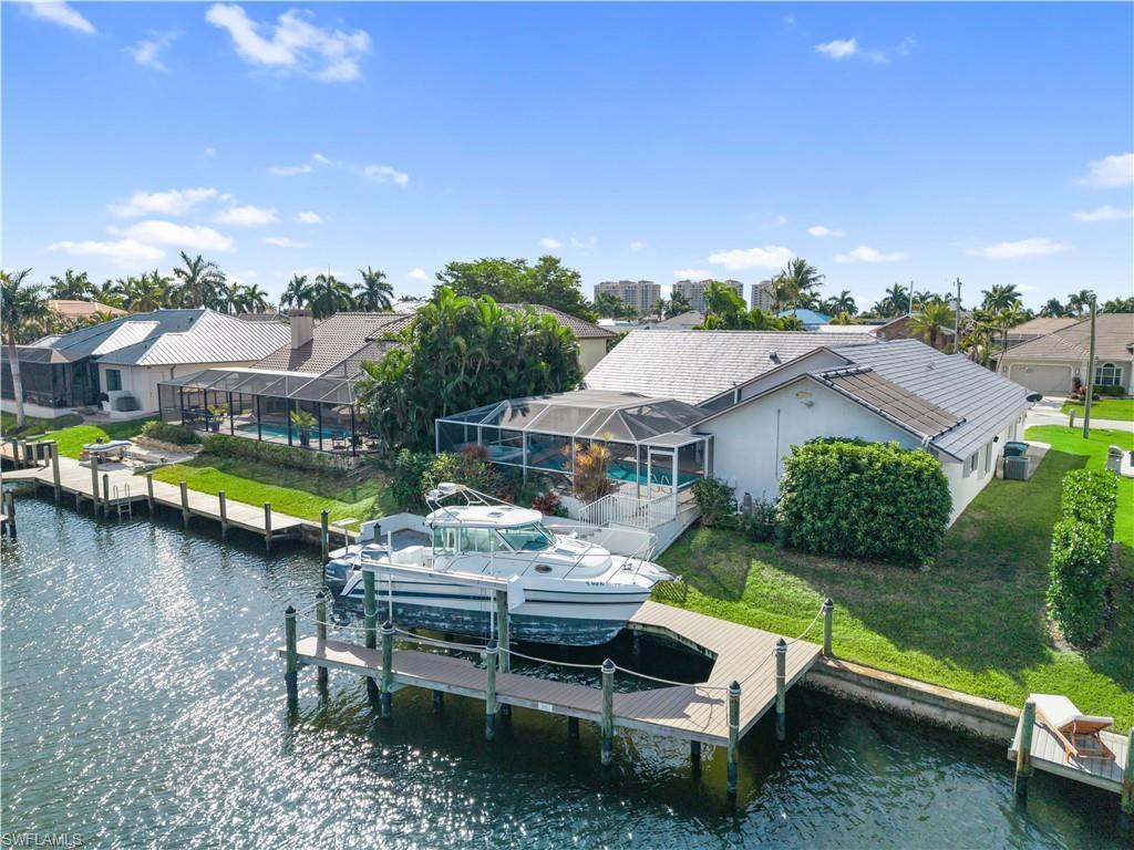 Image 4: Dock with glass enclosure, a water view, a yard, a residential view, and boat lift