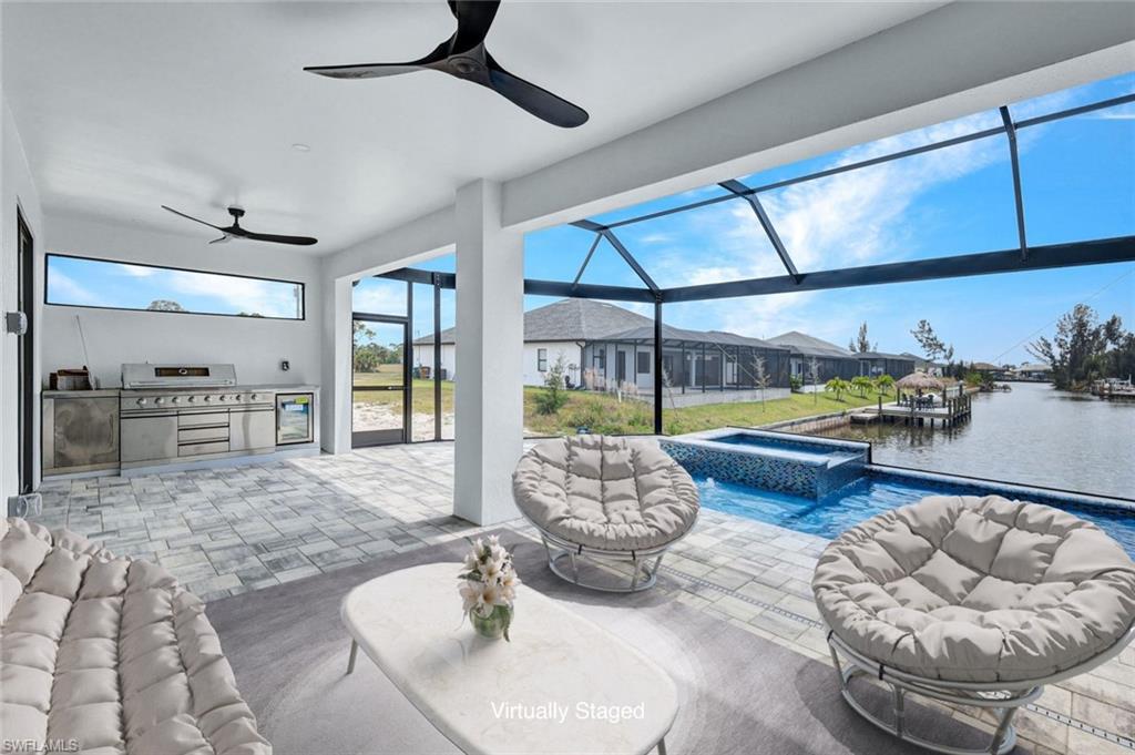 Image 4: View of patio with an in ground hot tub, ceiling fan, an outdoor kitchen, and an outdoor pool