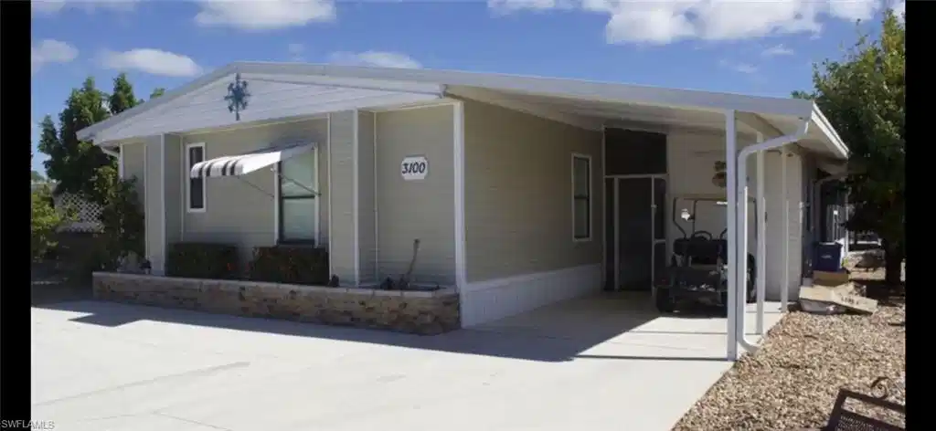Image 1: View of front of house with driveway and a carport