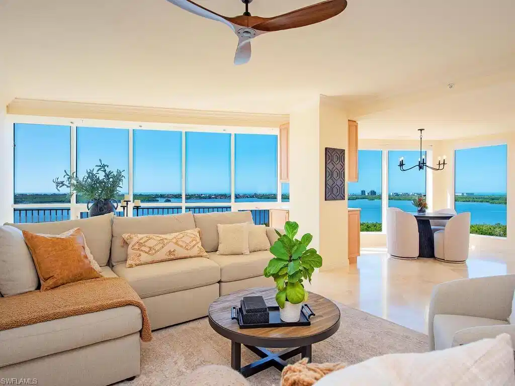 Image 1: Living area with a water view, a chandelier, a ceiling fan, plenty of natural light, and crown molding